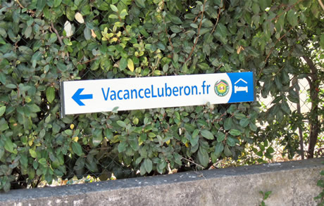 Au 59 chemin de Peliboux, un panneau est placé au début du passage en tout-venant à emprunter pour parvenir à VacanceLuberon.fr.