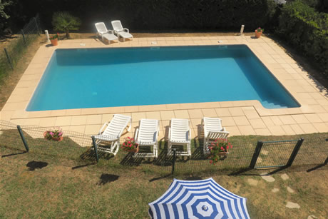 Une barrière métallique  entoure la piscine. L'accès est réalisé par un portillon à double verrous.