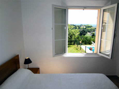 La chambre du bas a une vue sur le lever du soleil et la piscine.